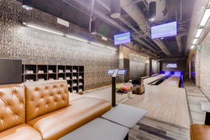 Two-lane bowling alley with leather couches.
