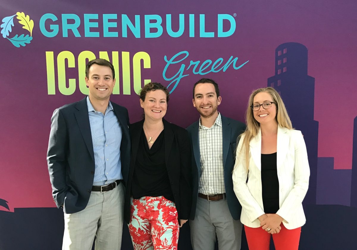 Four Unico Sustainability employees pose in front of a USGBC Greenbuild conference backdrop