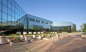 Plaza and exterior of Harlequin Plaza, a glass four-story office in Colorado.