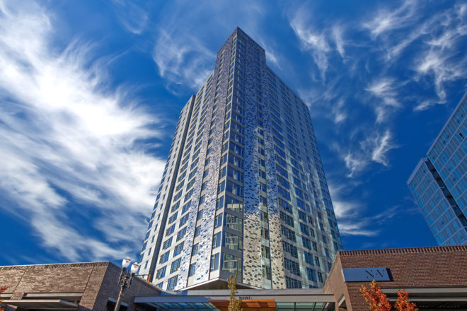 NV, Unico's 26-story development in Portland, Ore. A modern tower with unique tiling on the exterior.