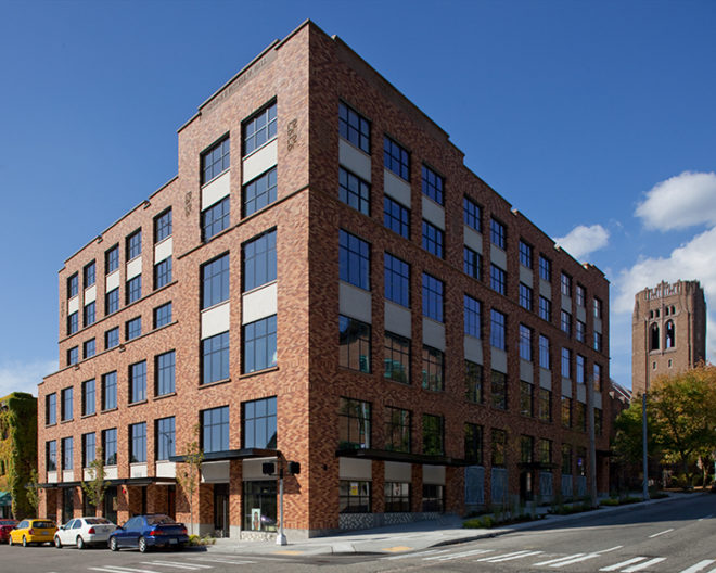 Exterior corner of Russel Hall, a six-story brick building with large windows located in Seattle's University District