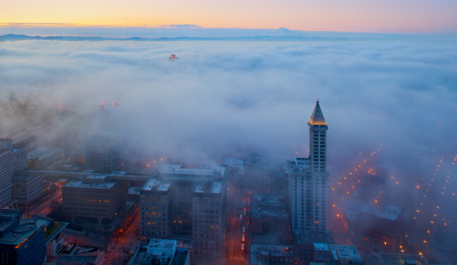 Aerial view of Smith Tower and Seattle's Pioneer Square neighborhood, with dense fog covering the city.