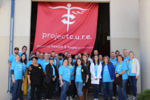 Unico employees in Denver were joined by leadership as they sorted, packed, and ship medical supplies with Project C.U.R.E. In the photograph, the team poses for a group photo in front of the Project C.U.R.E. banner.
