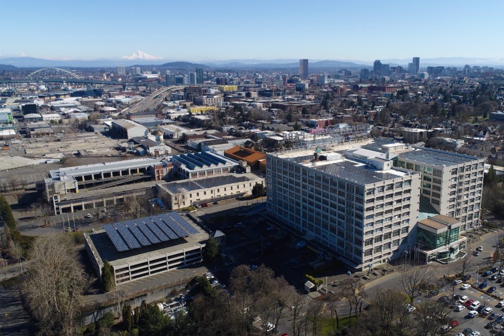 An aerial photograph of the Montgomery Park Campus which was acquired by commercial real estate investment company Unico Properties on Mar 20, 2019. The image shows the iconic Montgomery Park building and the American Can Complex and its relation to Portland's urban core.